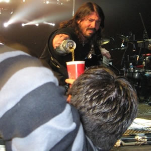 Dave Grohl bebe cerveja com fã em cima do palco